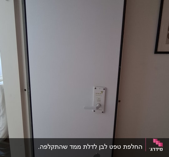 דלת לבנה עם קילוף צבע בתחתית